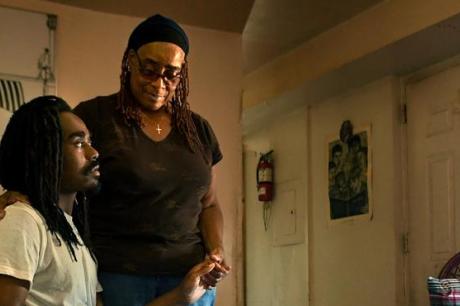 mother and son sitting in apartment looking worried