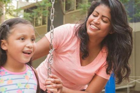 photo of mother pushing child on swing