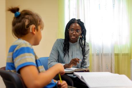 photo of teacher working with student in the classroom
