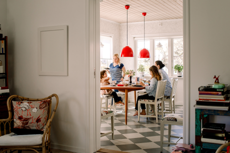 Photo of a mother and daughters having breakfast at a kitchen table.
