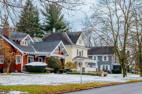 Three suburban houses on a snow-dusted street