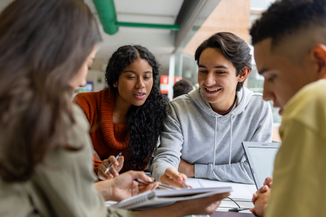 Four college-age students work on an assignment together at a table