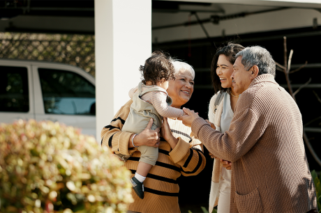 Photo of a multigenerational group of family members reuniting in a yard. 