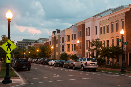 Quiet residential street with modern townhomes at dusk.