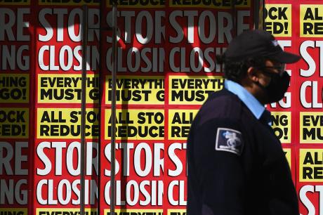 Man walks in front of a store that's going out of business