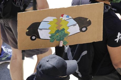 A protester carries a sign during a "Defund the Police" march from King County Youth Jail to City Hall in Seattle, Washington on August 5, 2020. (Photo by JASON REDMOND/AFP via Getty Images)