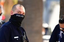 Los Angeles Police Department (LAPD) officers wear facial covering while monitoring an "Open California" rally in downtown Los Angeles, on April 22, 2020. 