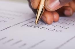 Hand holding pen over datasheet