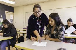 photo of teacher working with student in classroom