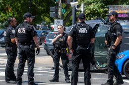 A group of police officers in the middle of a street. 