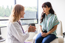 A doctor and patient sitting down.