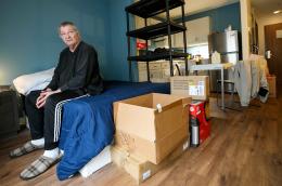 A man in a room with moving boxes. 