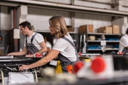 Several people work on machines in a factory
