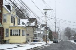 Photo of a street lined with colorful houses on a snowy day.