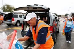 A volunteer hands out food at a food bank.