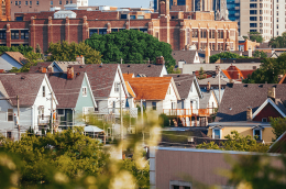An image of the Milwaukee skyline with houses, buildings and trees