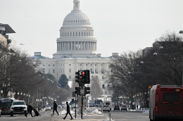 Photo of the Capitol building and a busy street on a gray winter day.