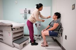 A nurse taking a patient’s blood pressure and temperature at a doctor’s office.