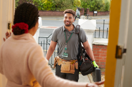 photo of handyman standing outside of a house
