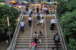 Pedestrians climbing stairs to an outdoor food court in New York City.