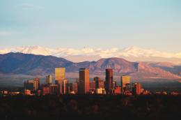 The Denver city skyline silhouetted against the Rocky Mountains.