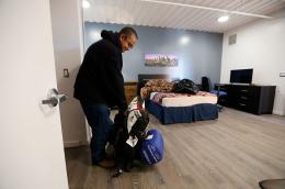 A man setting down his belongings inside an apartment.