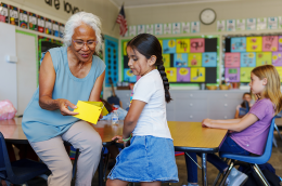 photo of teacher helping elementary age student during class