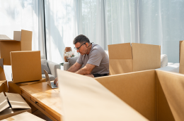 photo of a man, during a transfer, packing and using his laptop