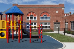 A colorful jungle gym outside an elementary school.