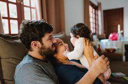 Two young parents holding their baby.