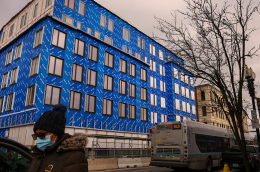 Photo of a pedestrian walking by a mixed-income housing project in Boston.